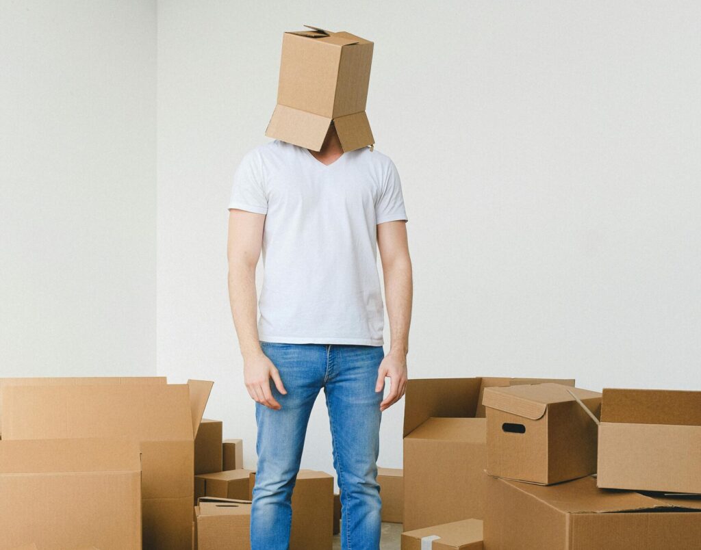 homme entouré de cartons de déménagement